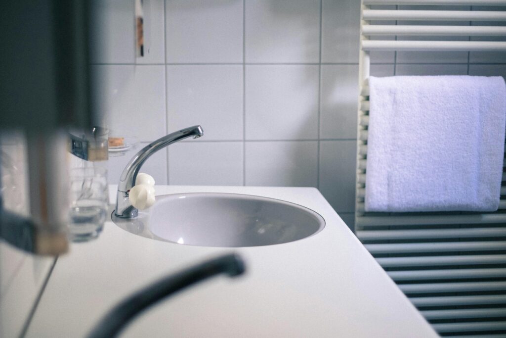 Un lavabo de baño limpio y minimalista con un grifo moderno y una toalla blanca.