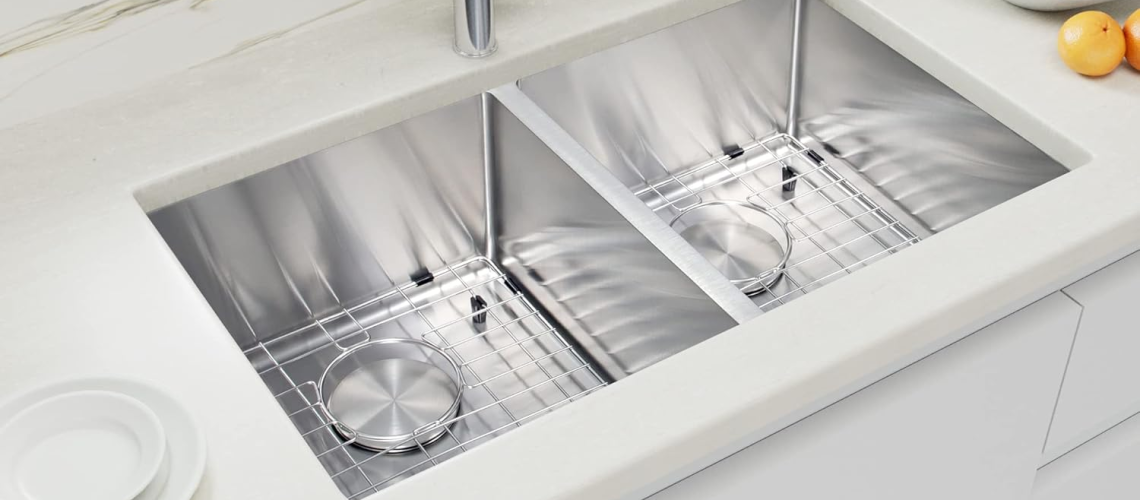 Modern kitchen with a stainless steel double-basin undermount sink, sleek chrome faucet, and white countertops.