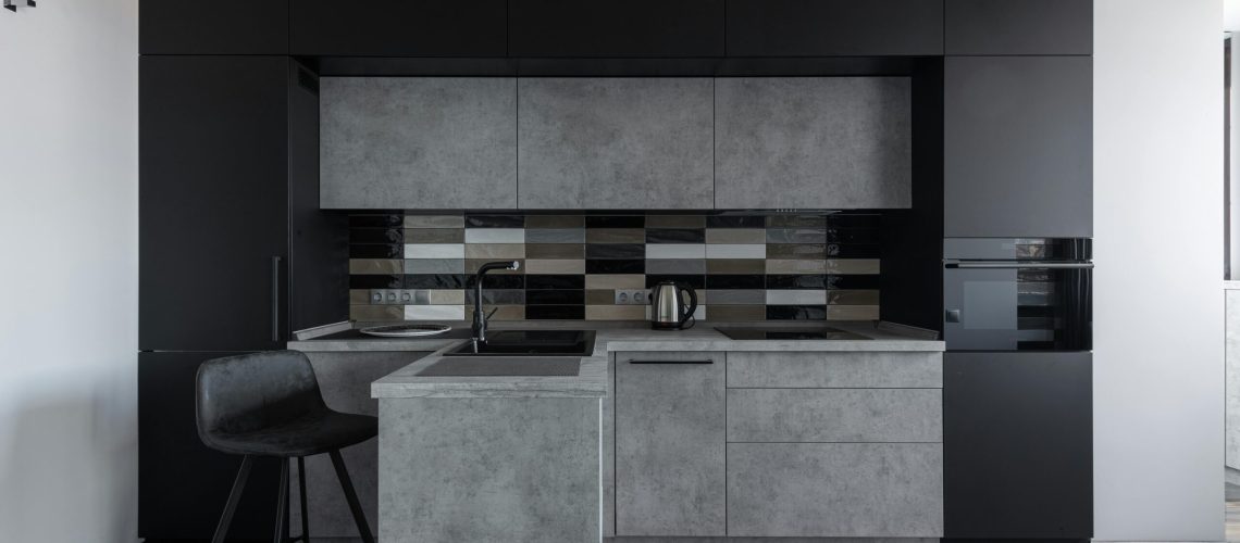 Sleek modern kitchen with black and gray cabinetry, perfect for minimalist decor.